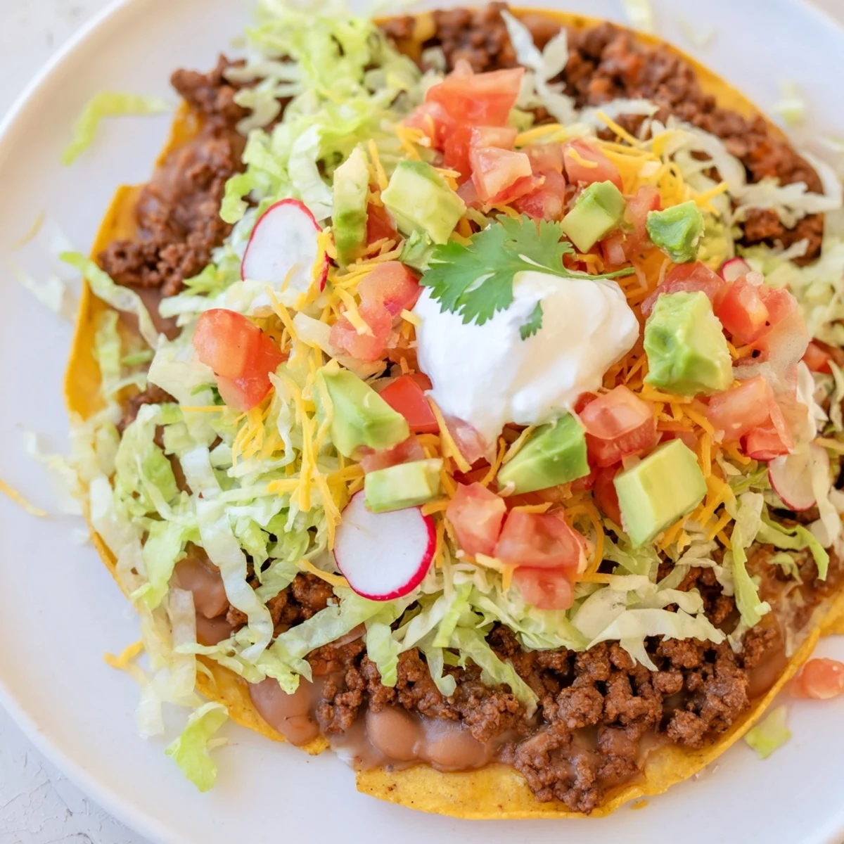 A close-up of delicious Beef Tostadas with seasoned beef, crisp toppings, and melted cheese, ready to eat.