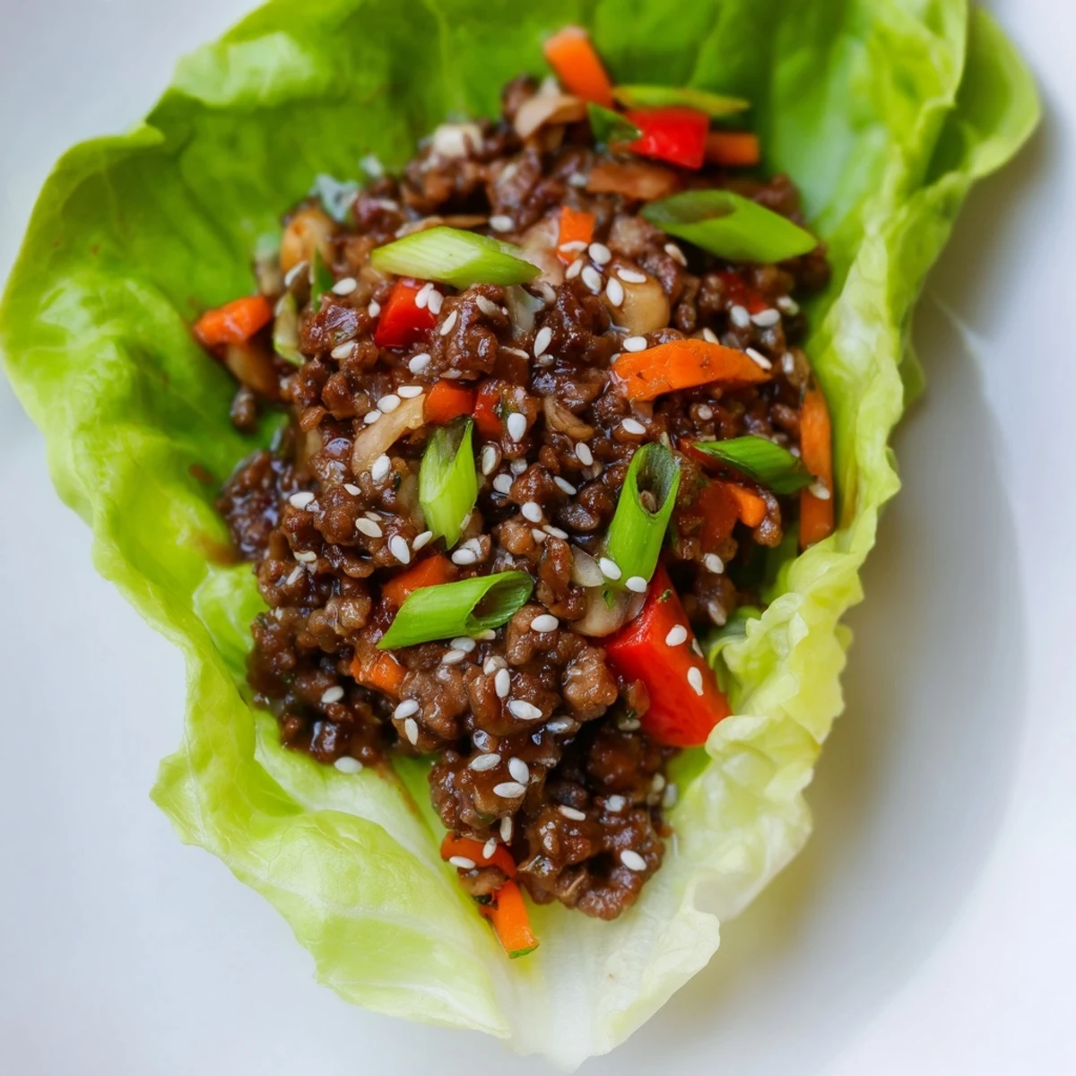 Sizzling pan of ground beef and aromatics tossed in hoisin, stuffed into buttery lettuce leaves for an easy, dairy-free weeknight meal.