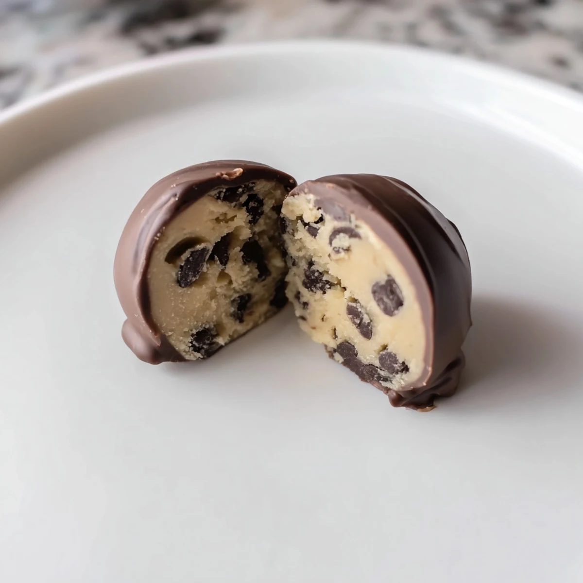 Close-up of Chocolate Chip Cookie Dough Truffles showing soft, edible dough interior studded with mini chips under a smooth chocolate shell.