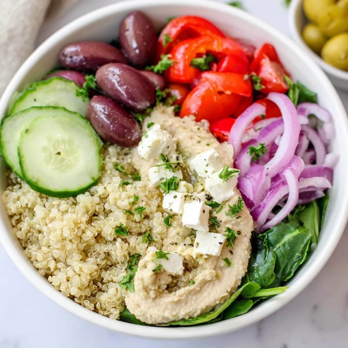 Freshly assembled Mediterranean Quinoa Bowl with Hummus garnished with parsley, drizzled with lemon-oregano dressing, and ready to serve.