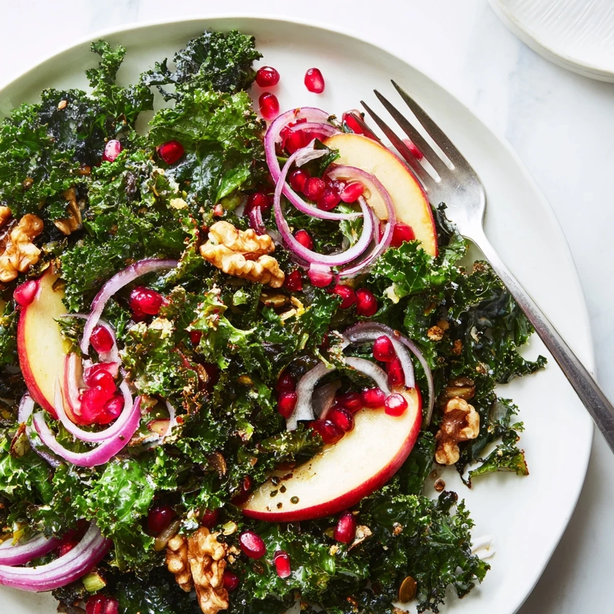 Freshly massaged kale forms the base of this Winter Kale Salad, topped with juicy pomegranate arils, crunchy pepitas, and tangy feta cheese.