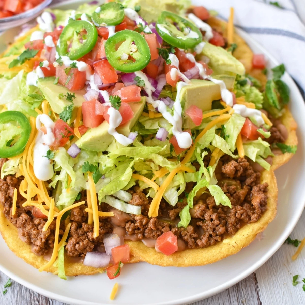 Crispy corn tostadas layered with seasoned beef, creamy refried beans, fresh lettuce, tomato, and a sprinkle of melted cheese.  