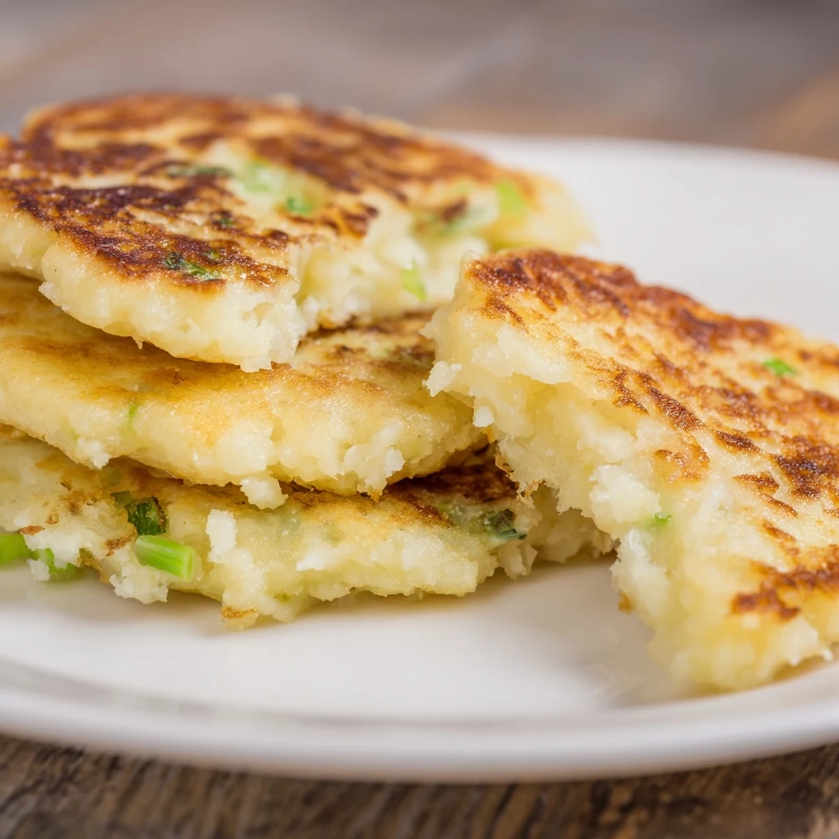 Close-up on tender Irish Boxty Potato Pancakes with Scallions, highlighting the mixed textures of grated and mashed potatoes.