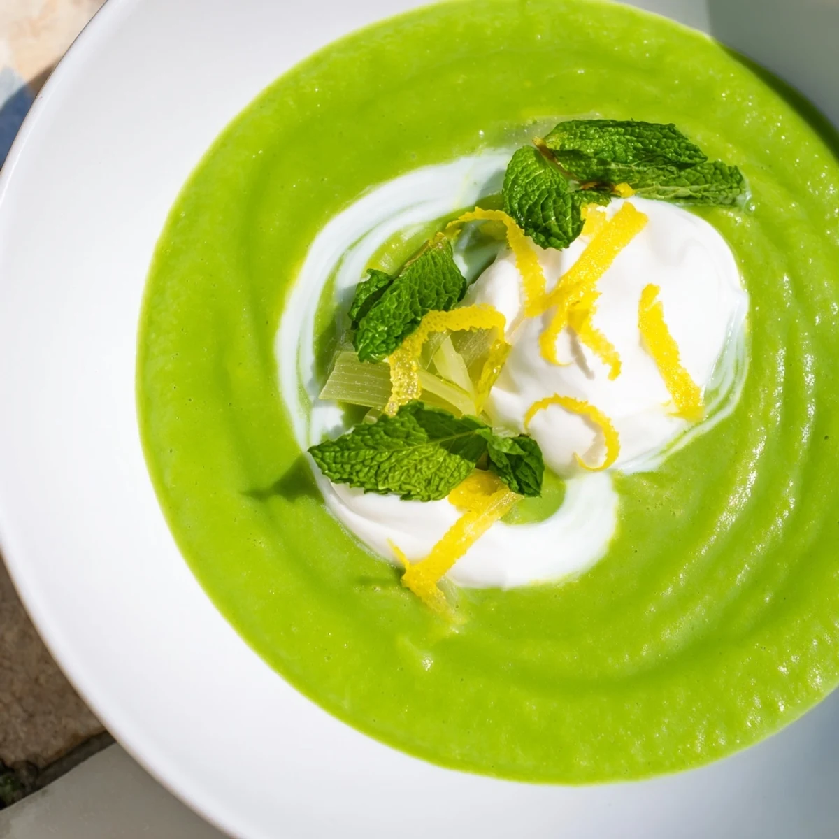 Spring Pea Soup with Mint and Crème Fraîche served in a rustic bowl, highlighting its velvety texture and bright green color.