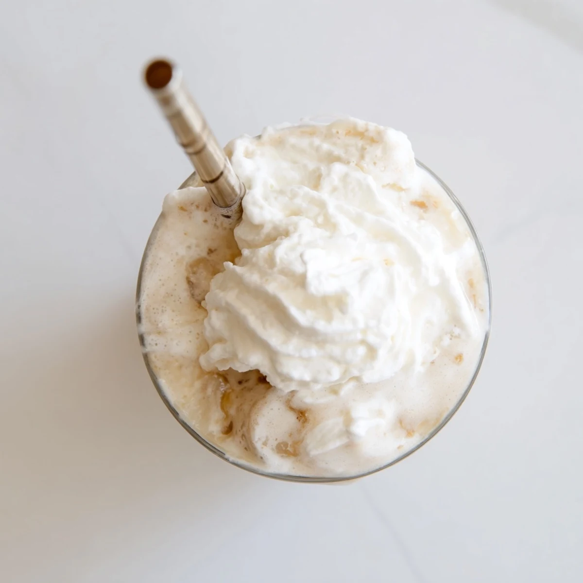 Close-up of Starbucks Vanilla Bean Frappuccino with rich vanilla bean specks in the ice cream base and a light whipped cream swirl.