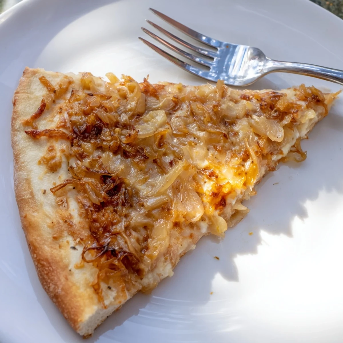 Sliced sweet onions cover the Caramelized Onion Pizza With Melty Cheese on a wooden board.
