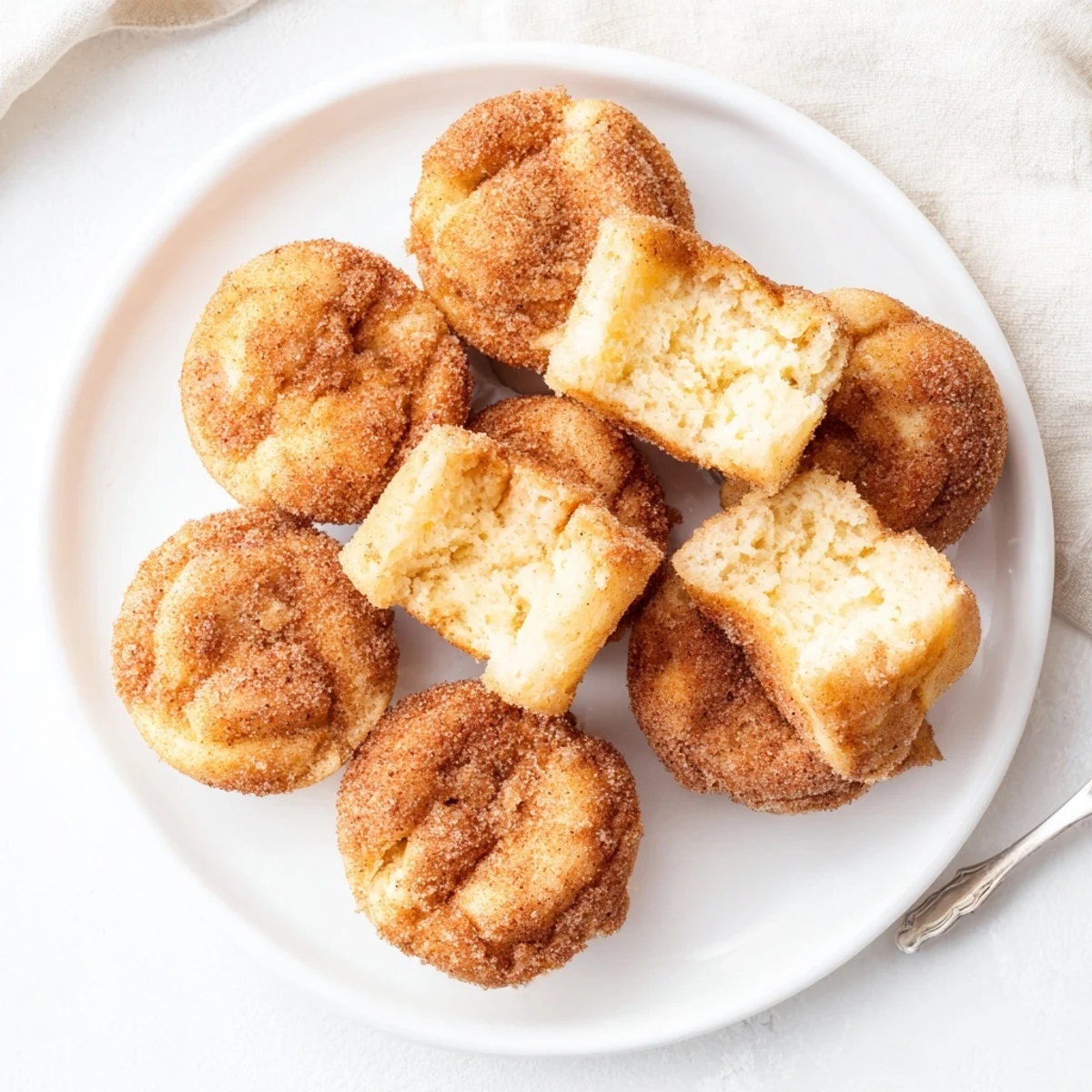 Freshly baked Cinnamon Sugar French Toast Muffins with soft custardy centers, brushed with butter and ready to be served warm for breakfast.