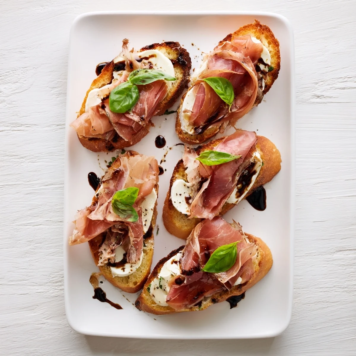 A close-up of golden Mozzarella Beef Prosciutto Crostini featuring creamy mozzarella, savory meats, and a glossy balsamic glaze, perfect for easy entertaining on a wooden board.
