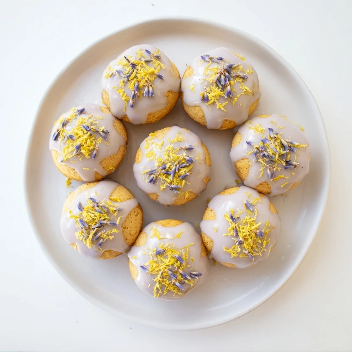 Golden mini lemon cakes drizzled with fragrant lavender glaze on a white serving platter