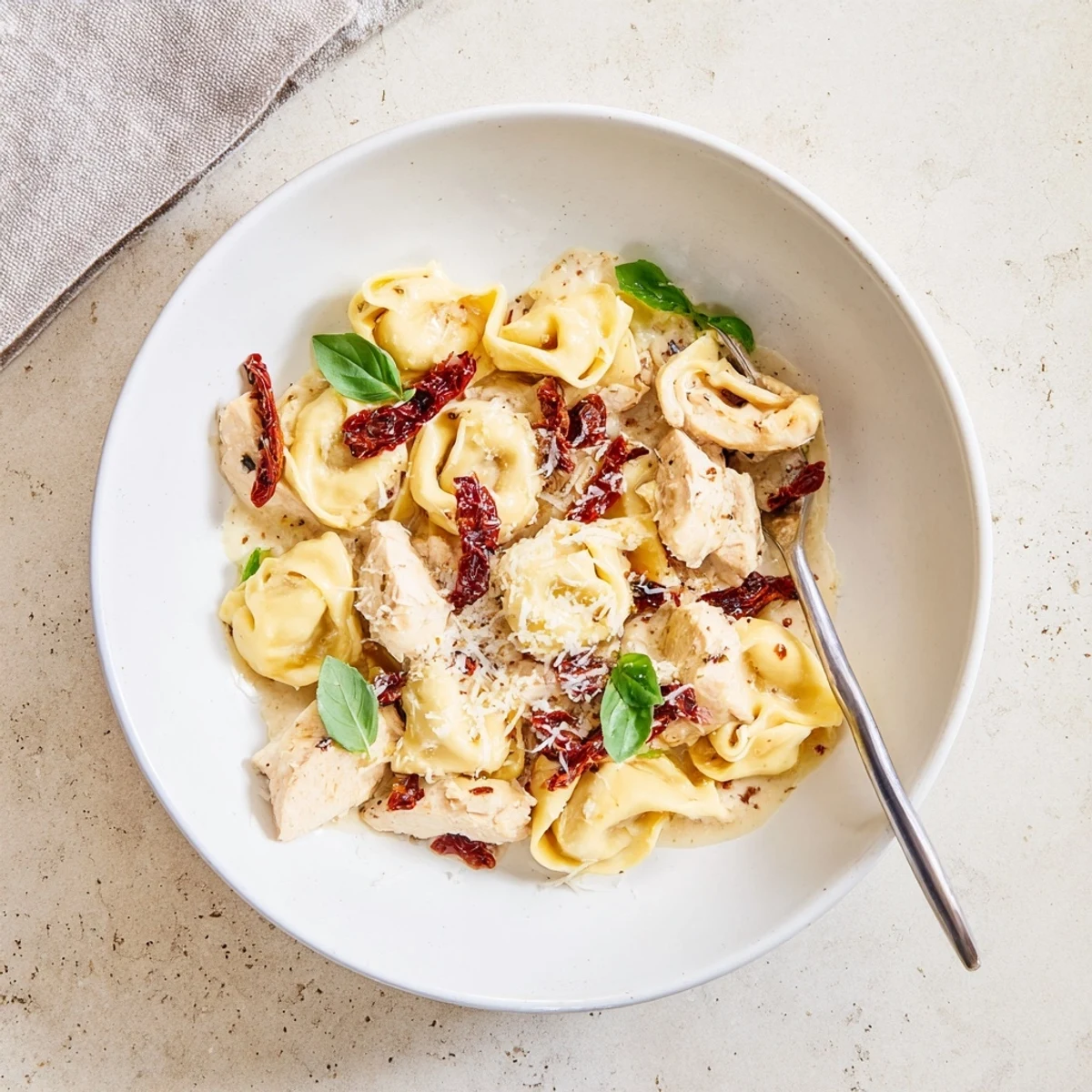 Golden brown chicken and cheese tortellini swimming in a creamy sun-dried tomato parmesan sauce