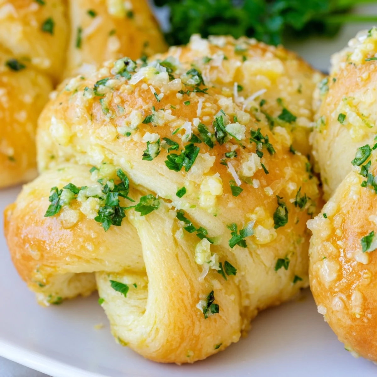 Soft pillowy gluten-free garlic knots arranged on a baking sheet, freshly baked with golden brown edges