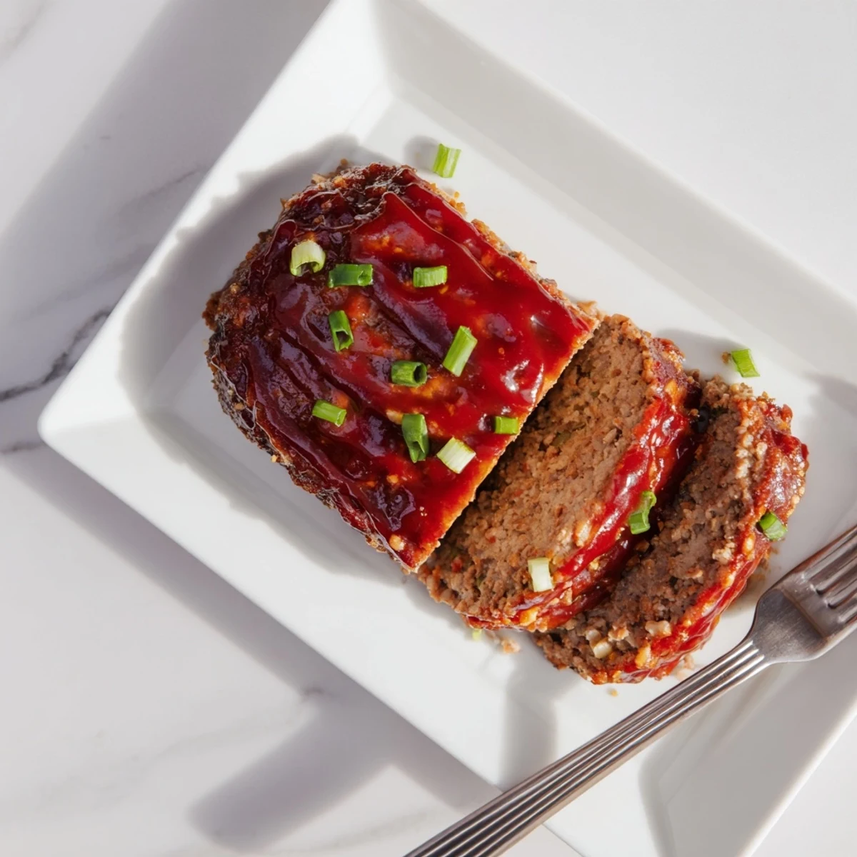 Juicy Korean meatloaf baked with spicy-sweet gochujang glaze on a wooden cutting board