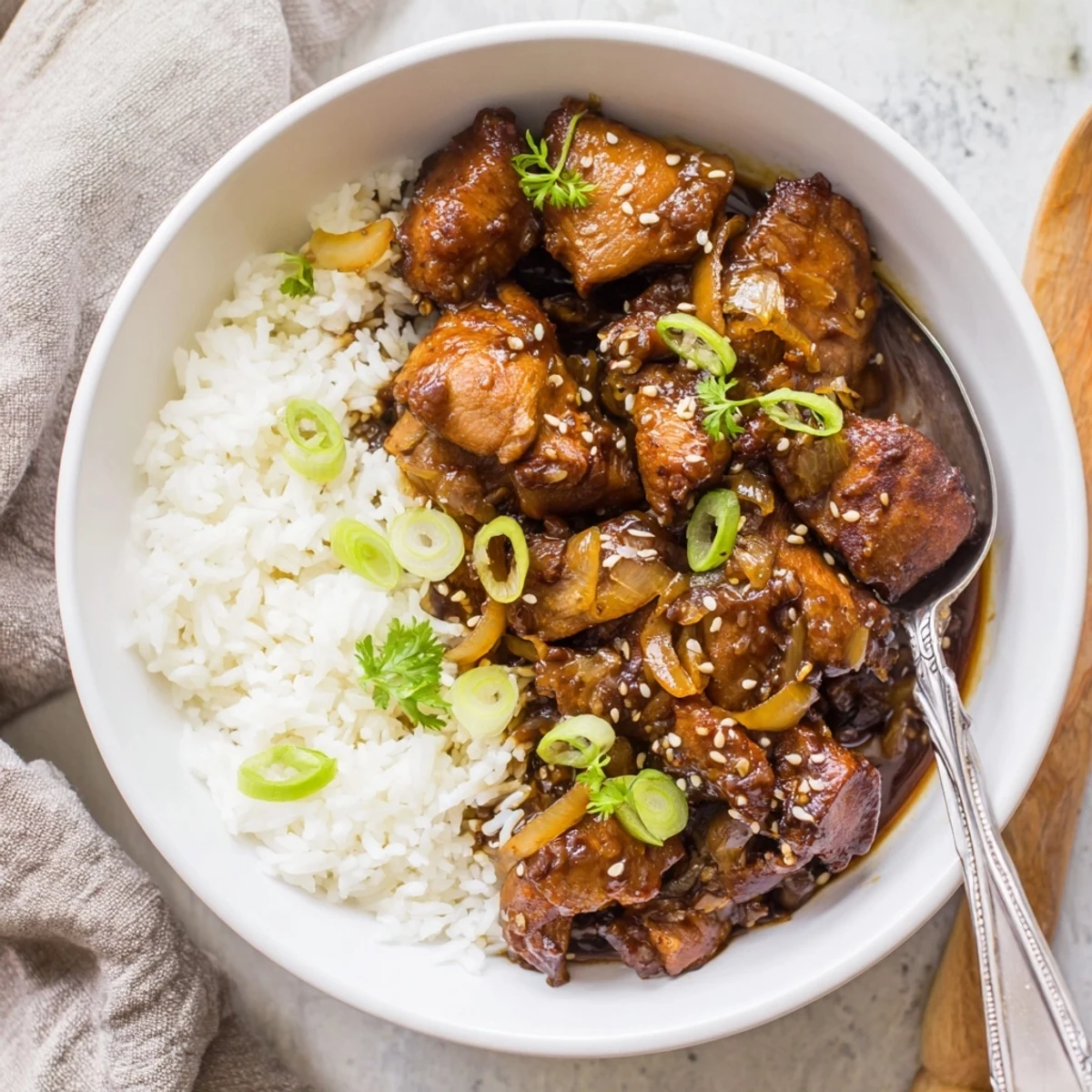 Golden chicken glazed in sticky caramel soy sauce served over fluffy white rice in a deep bowl