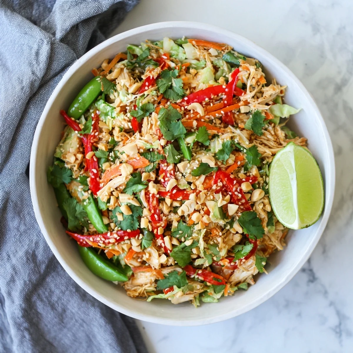Fresh no cook Asian chicken salad topped with crunchy peanuts and sesame seeds