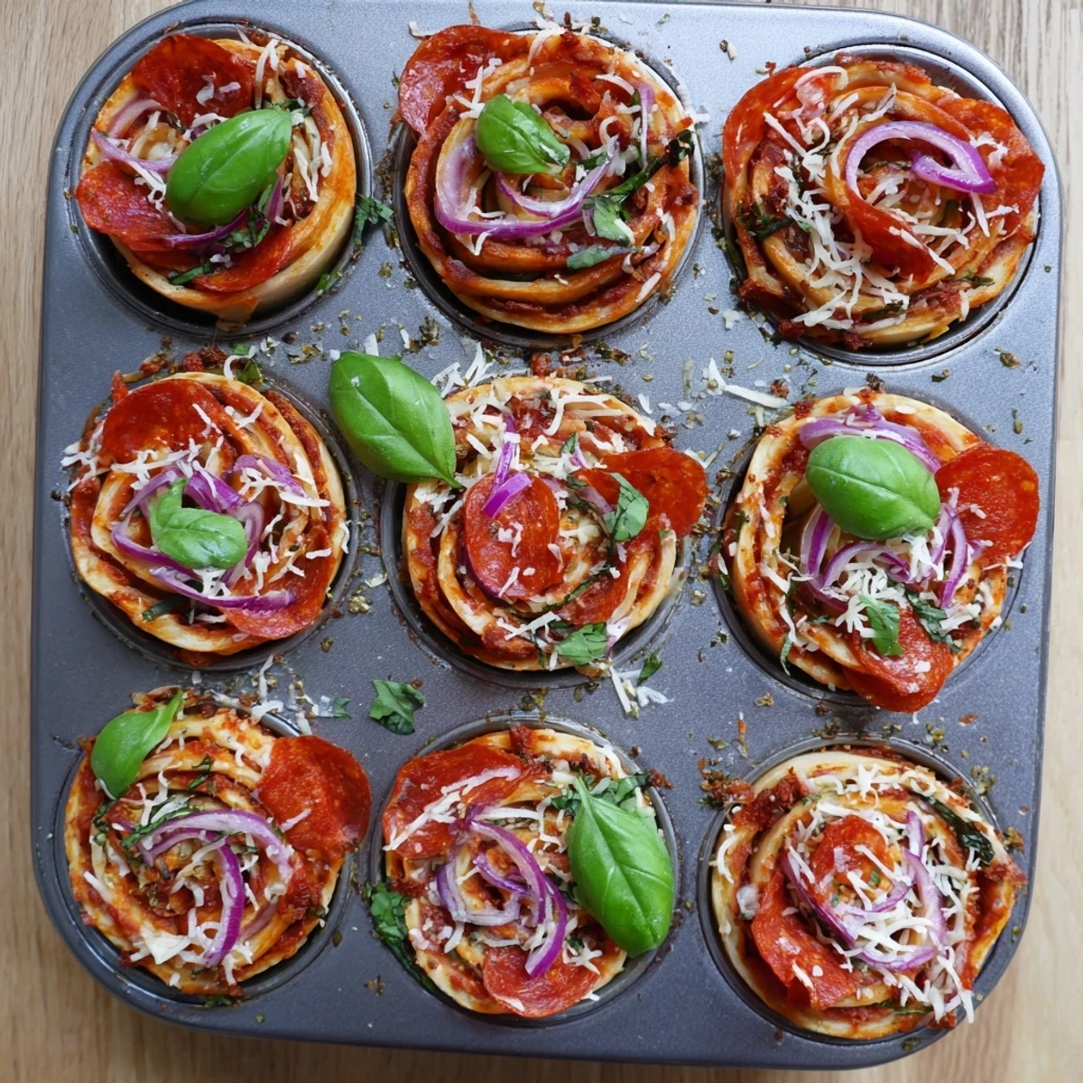 Golden easy pizza roses with bubbling mozzarella and colorful bell pepper slices in muffin tin