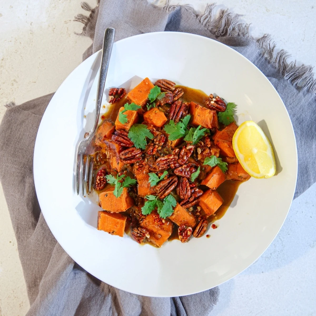 Silky slow-cooked sweet potatoes topped with spiced pecan crunch for a warming side dish