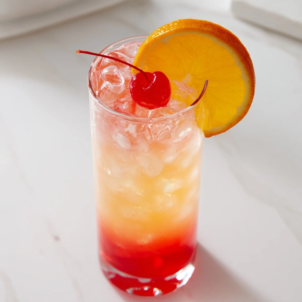 Refreshing Easy Shirley Temple Drink showing grenadine swirls with orange slice garnish on rim