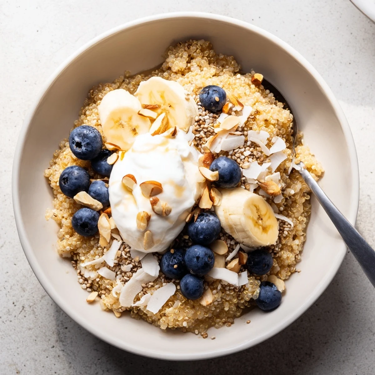 Vibrant morning blueberry quinoa breakfast bowl arranged with fresh fruit crunchy toppings and creamy yogurt layer