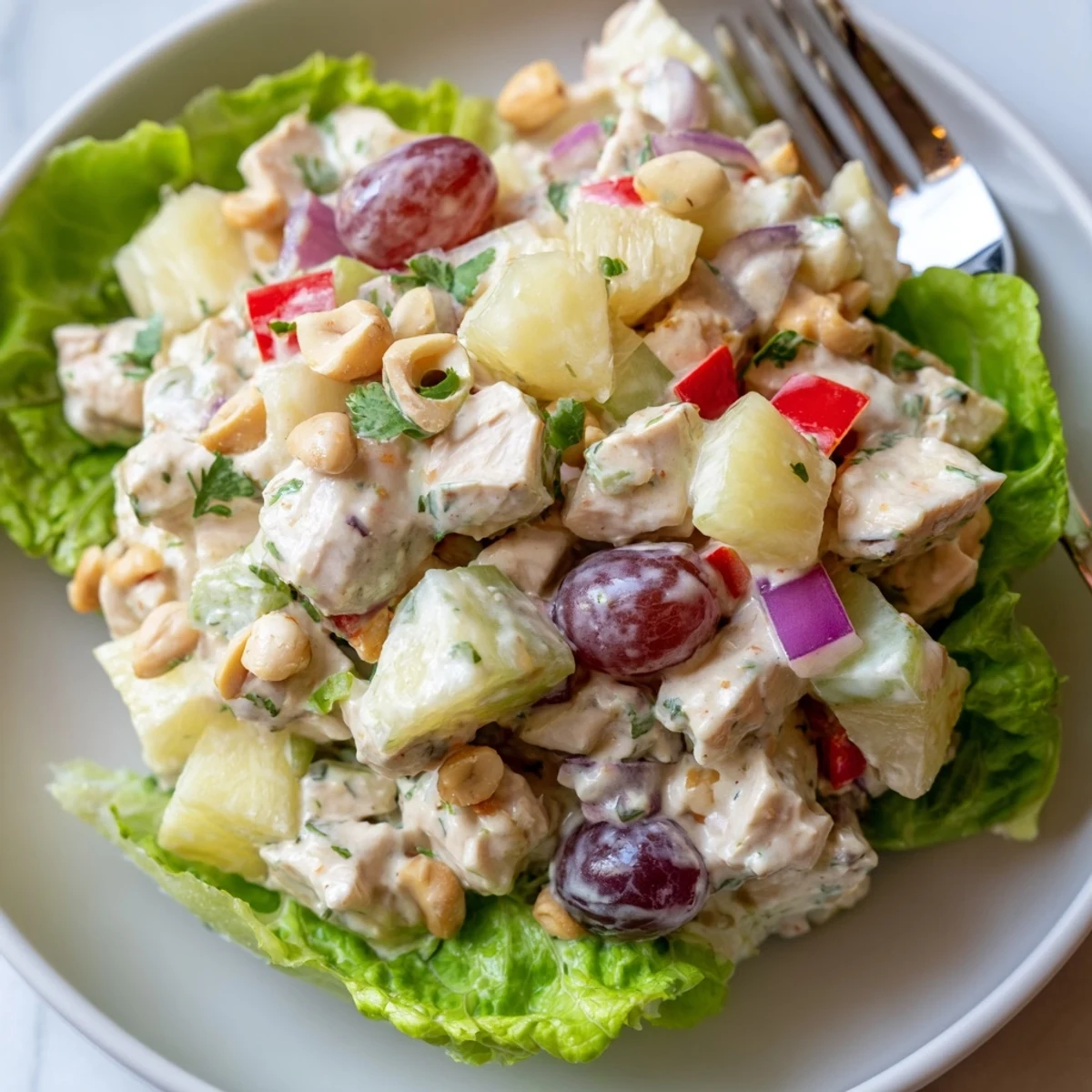 Chilled Hawaiian Chicken Salad Recipe served in halved pineapple for summer gatherings