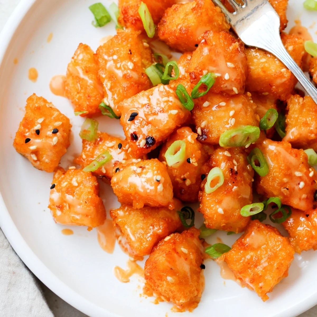 Pan-fried Bang Bang Salmon Bites with sesame seeds served over steamed rice.