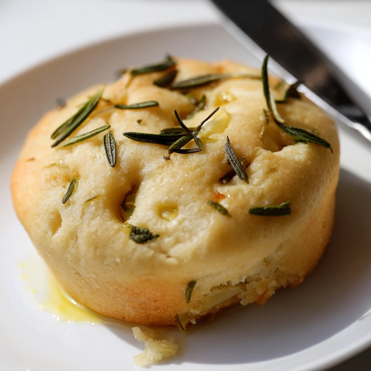 Golden Garlic Rosemary Focaccia Muffins topped with fresh sprigs and olive oil