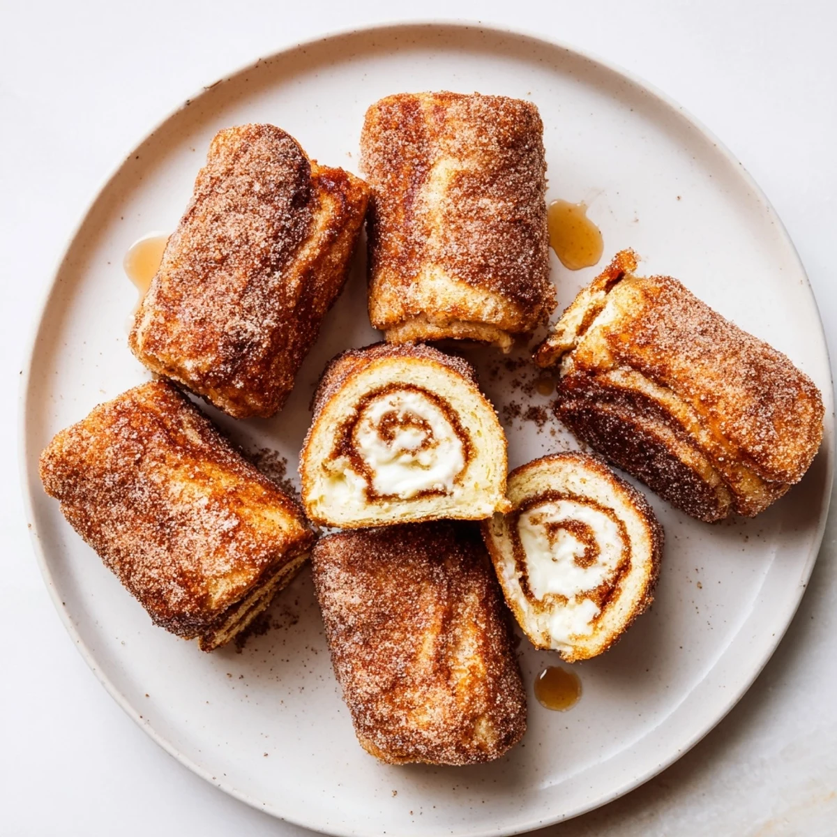 Warm Cinnamon Roll French Toast Roll Ups dusted with powdered sugar, steaming