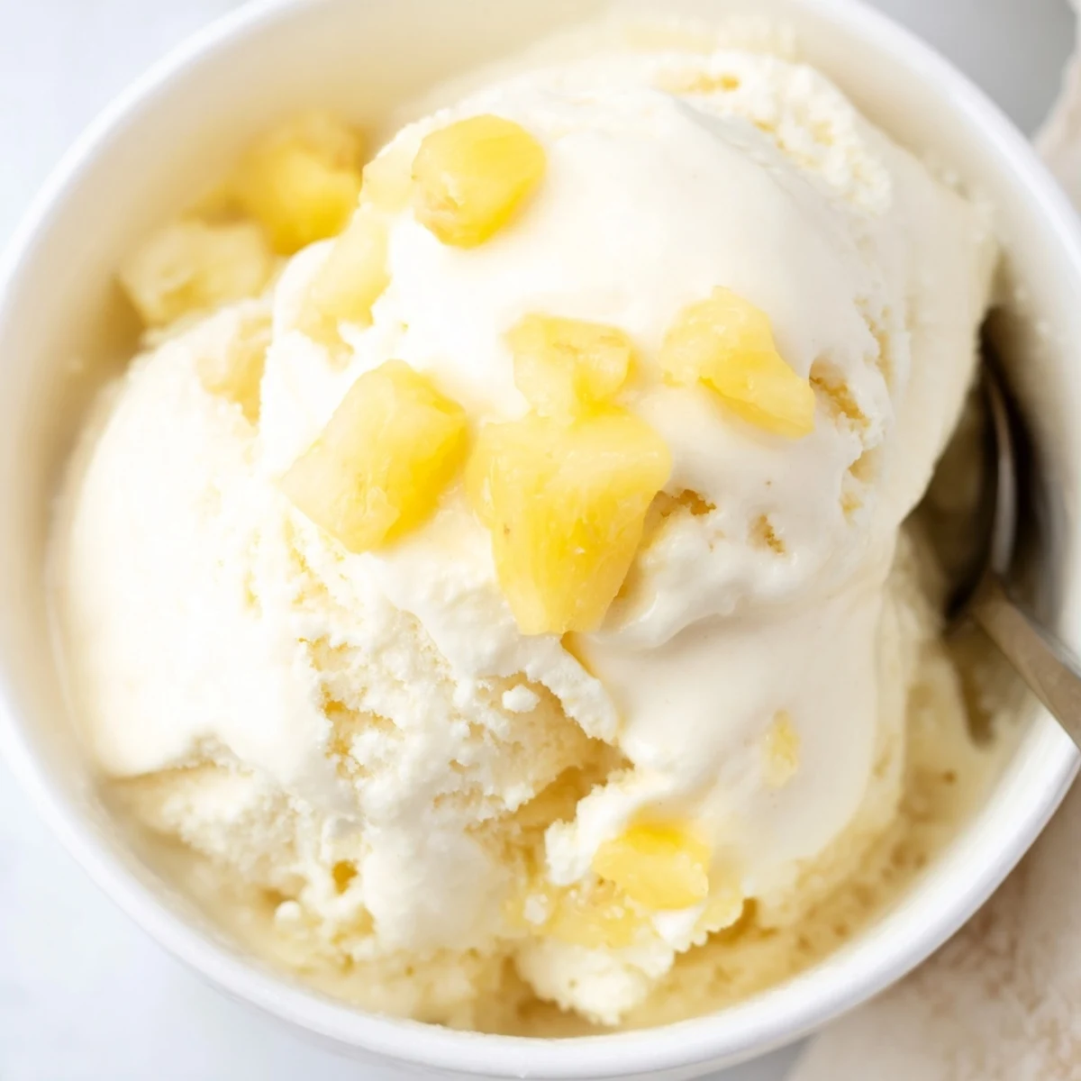 Creamy Pineapple Ice Cream Recipe: silky golden scoops topped with toasted coconut