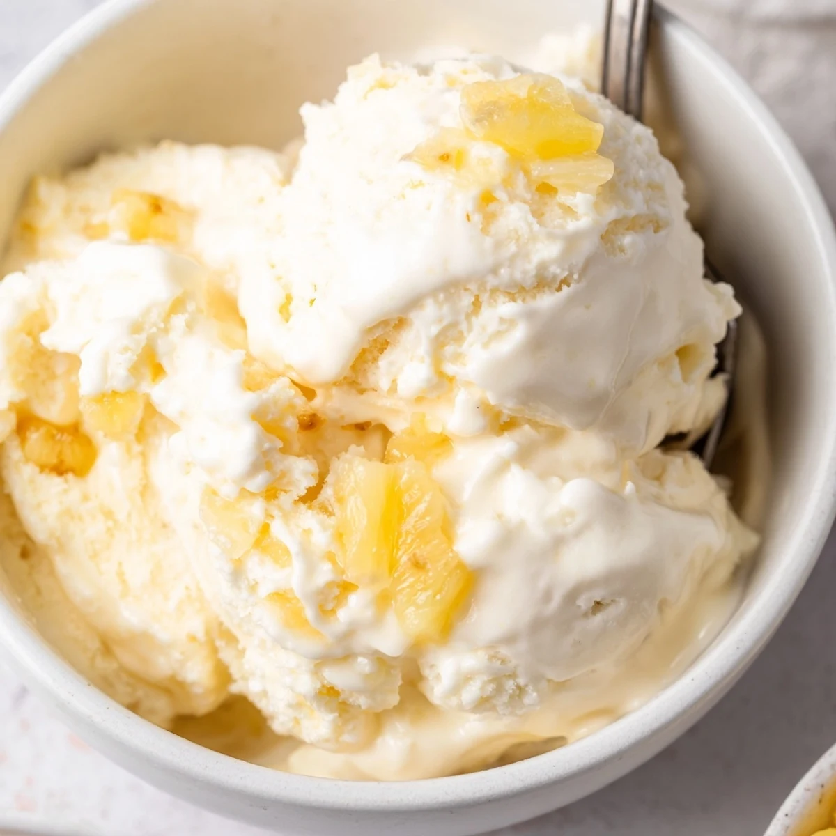 A chilled bowl of Creamy Pineapple Ice Cream with bright citrus aroma