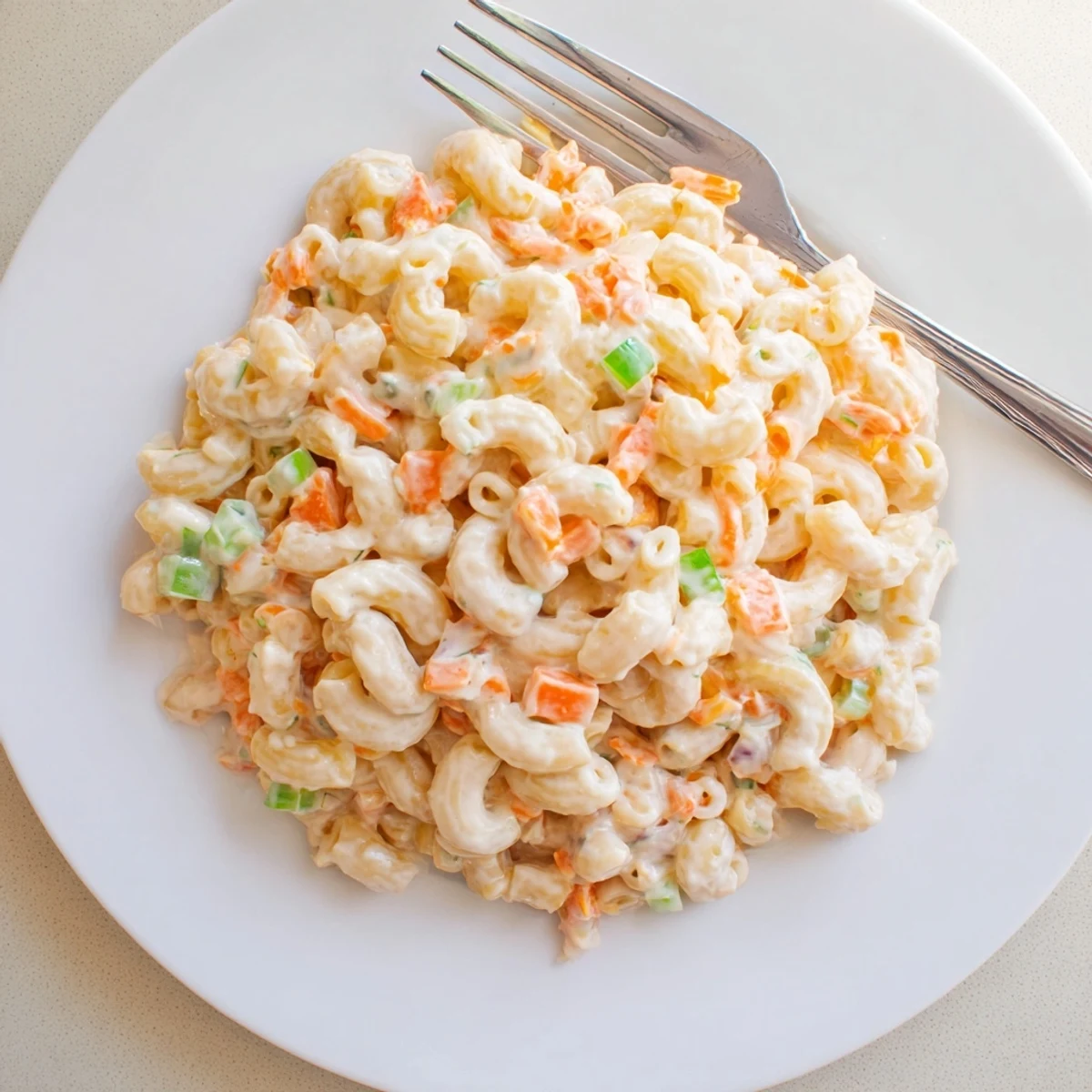 Close-up of Hawaiian mac salad showing smooth texture with colorful chopped vegetables throughout