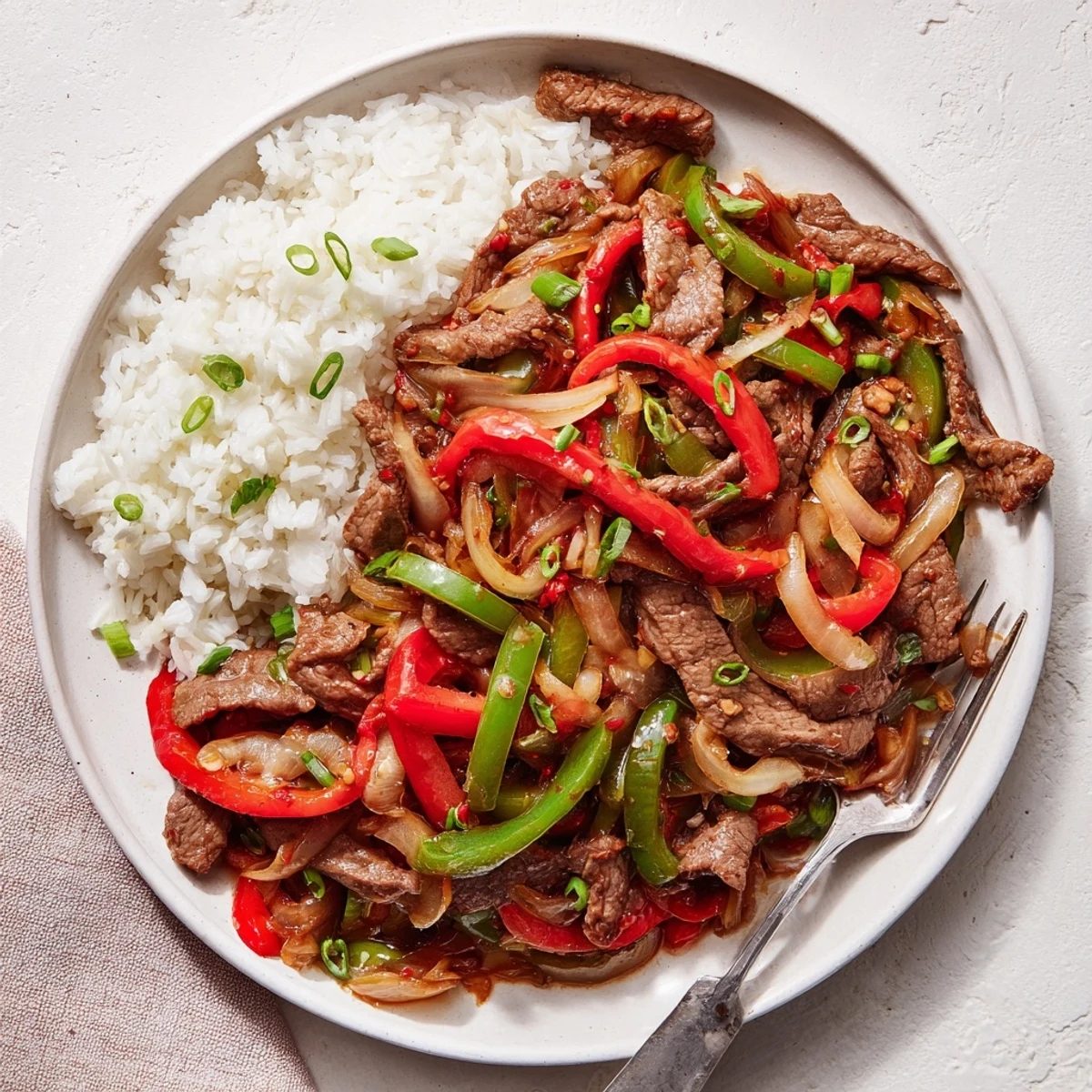 Close-up of spicy beef stir fry showcasing vibrant red and green vegetables in glossy sauce