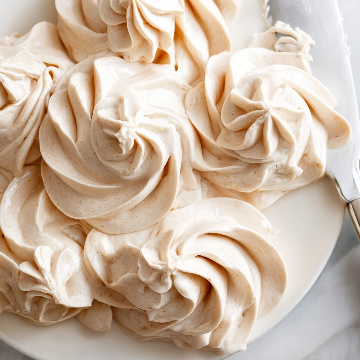 Glossy Italian meringue buttercream spread over a rustic naked birthday cake