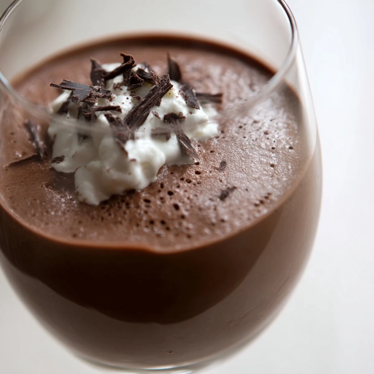 Silky chocolate mousse spooned into dessert bowls with dark chocolate shavings