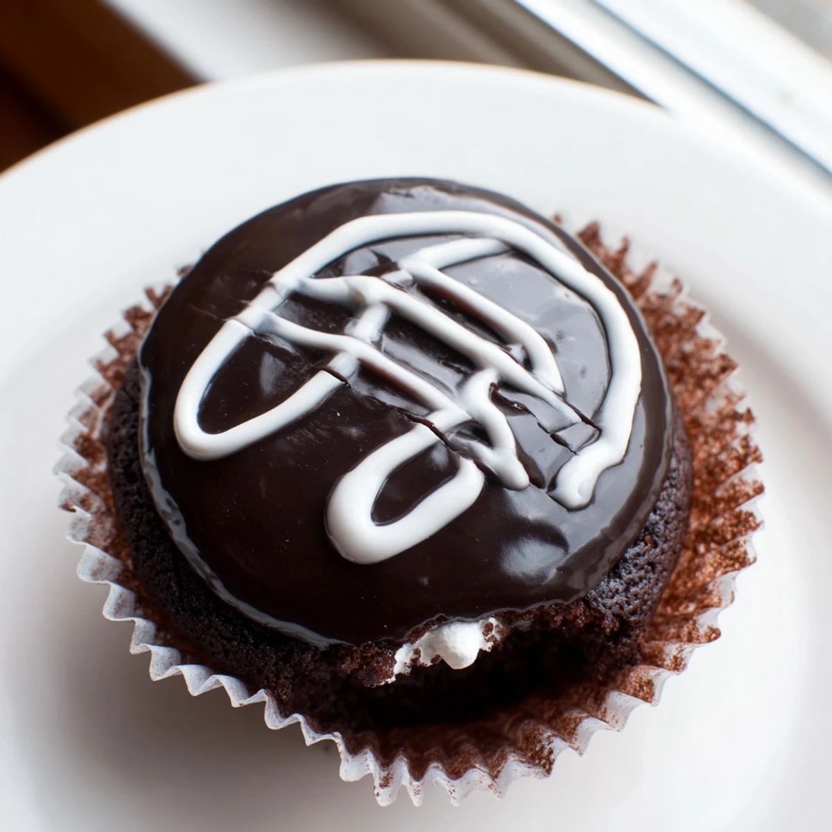 Homemade Hostess Cupcakes with glossy ganache topping and creamy marshmallow center