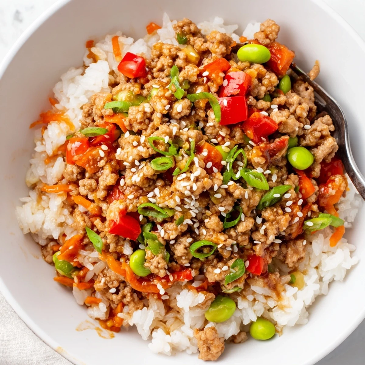 Steaming ground turkey rice bowls drizzled with savory soy ginger sauce